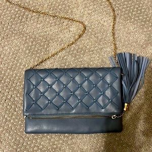 Blue clutch with gold crossbody chain.